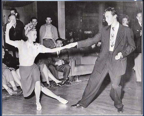 1940s vintage photo of swing dancers / Jitterbug dancers Jean Veloz and Ray Phelps dancing together in 1940s fashions. 