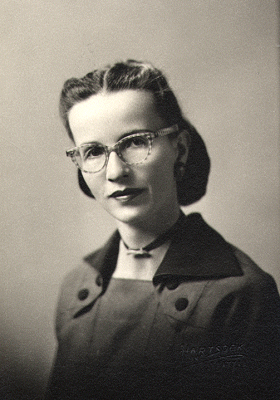 1940s vintage image of woman wearing glasses. The eyewear are checkered. Super 1940s hairstyle inspiration. 