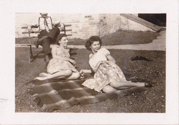 1940s vintage image of women at a picnic in a park in 1940s fashions. 