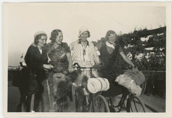 1920s vintage photo of 4 women with 1920s hairstyles and 1920s fashions on bikes heading to a picnic