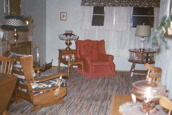 1950s photo of a livingroom with lots of lamps and big furniture. 