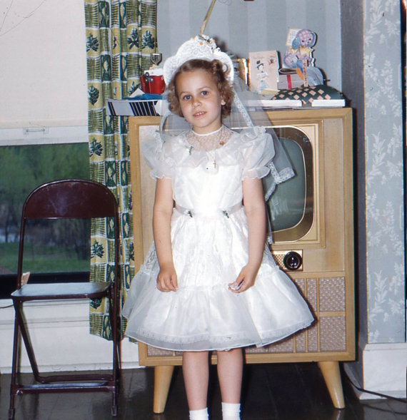 1950s vintage image of young girl and television -First Communion. 