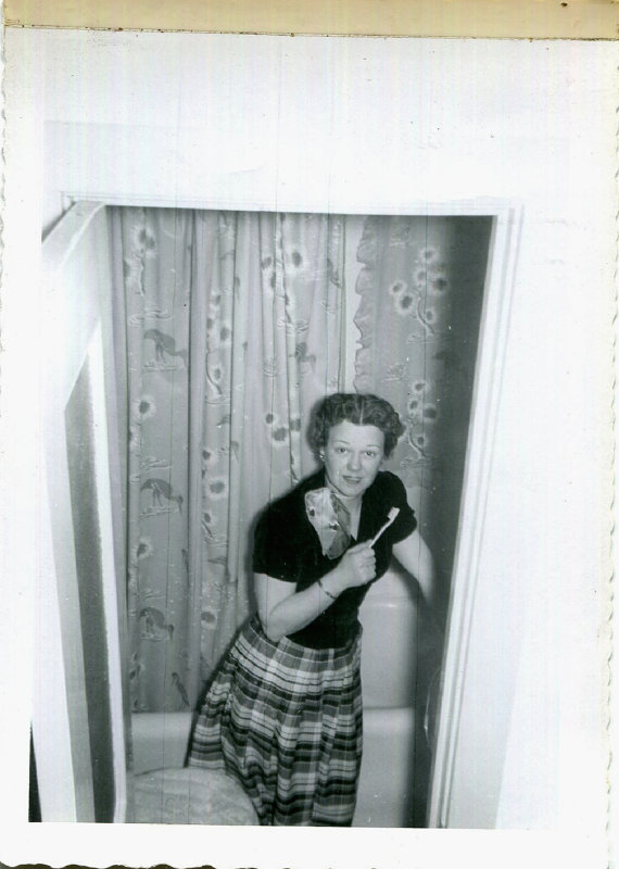 1950s woman in the bathroom brushing teeth vintage image