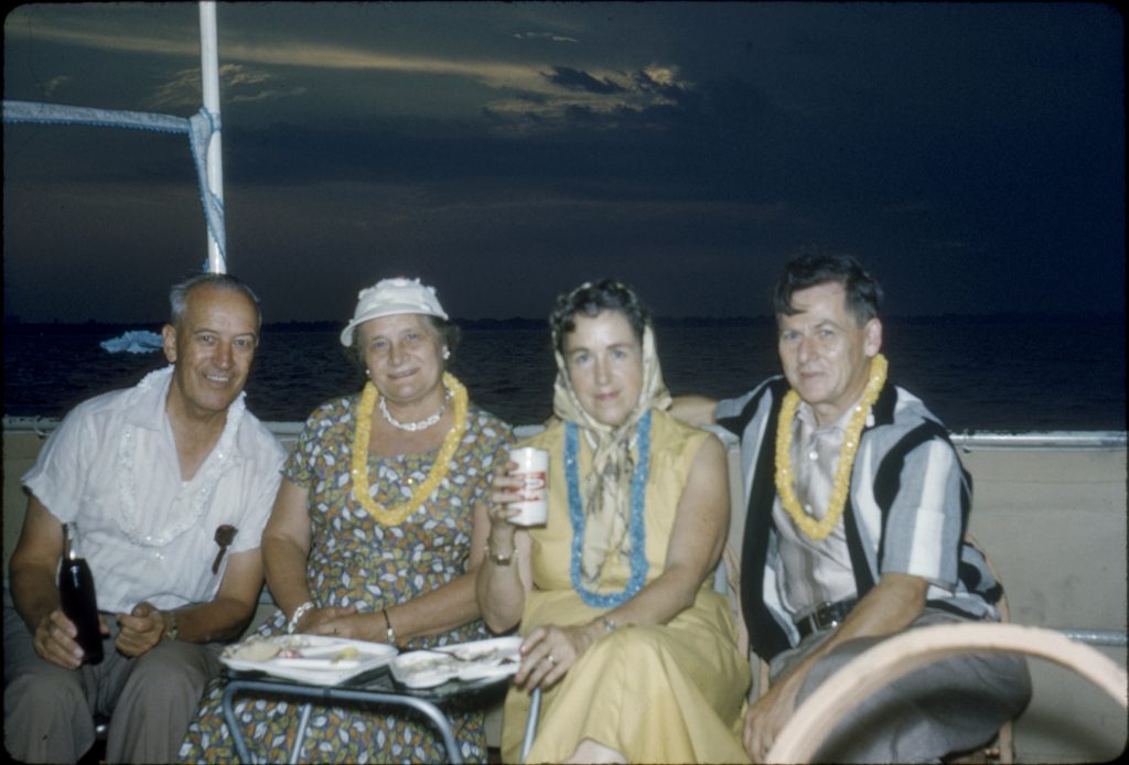 1958 Boat Cruise with friends wearing lei's and having a drink and some food together. 