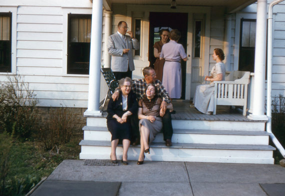 1950s vintage photo of a group of older people hanging out on a front porch.