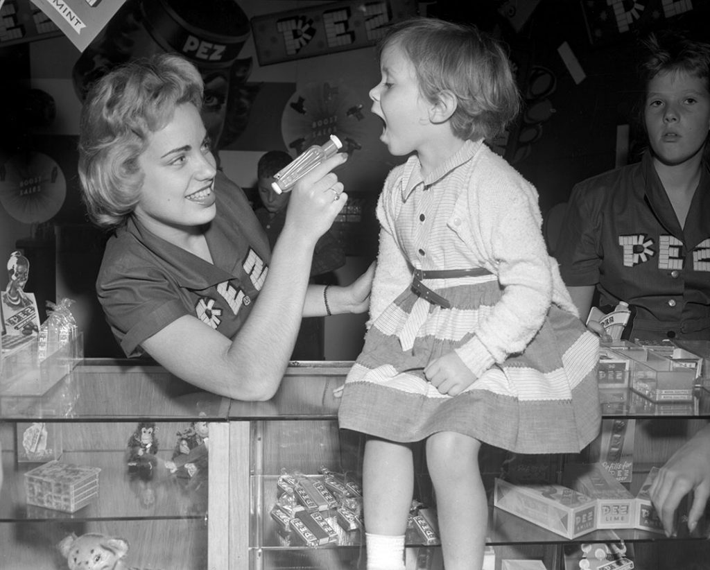 vintage image of a young girl eating pez at the CNE 1954. Pez Anyone? 1954 vintage photo of the Pez booth at the CNE. 