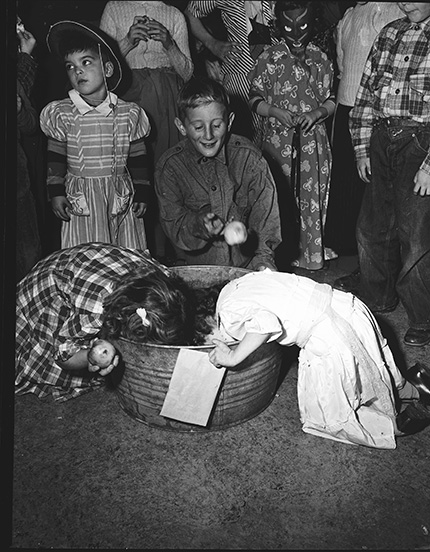 1940s vintage photo of a 1949 Halloween Party bobbing for apples contest. 