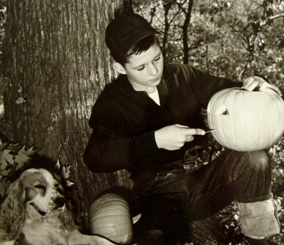 1950s Photo of a boy carving a pumpkin for Halloween. Vintage Halloween Photo. 