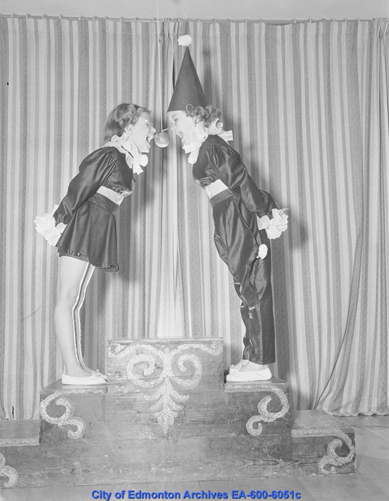 Vintage image of children playing snap apple in the 1940s dressed as clowns for a Halloween party. 