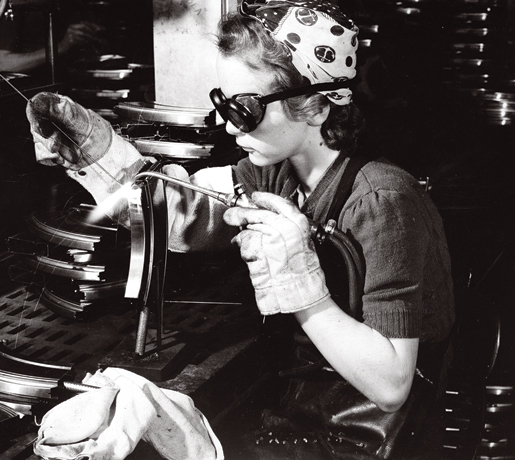 1940s vintage photo of a welder works on a Bren gun at John Inglis Company Ltd 1942 doing her part for the WW2 Homefront effort in Canada.