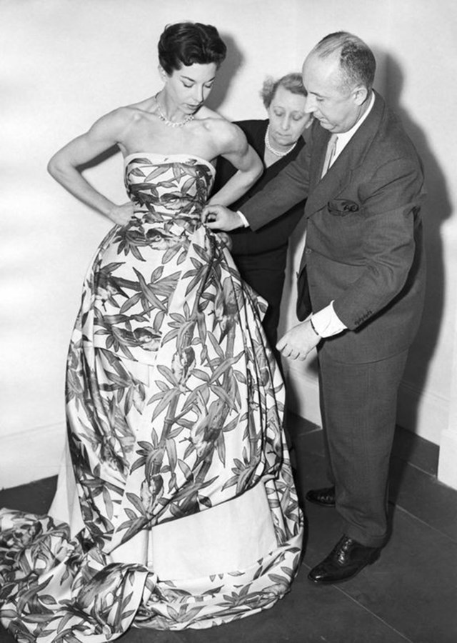 1950s Vintage Photo: Christian Dior with model Dorothy Emms reviewing one of his evening gown creations, 1952. 1950s fashion