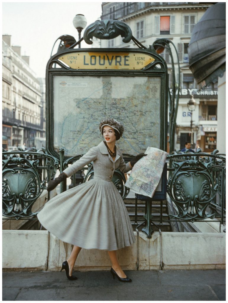 Christian dior vintage ad 1957 featuring a model wearing a Dior 1950s Dress outside the Louvre Metro station, Paris. 