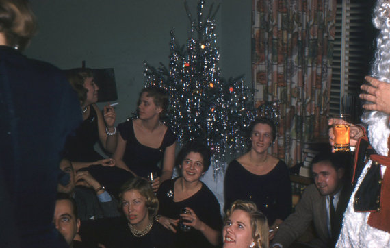 1950's Kodachrome slide of Christmas party with Santa. Everyone is wearing black. 