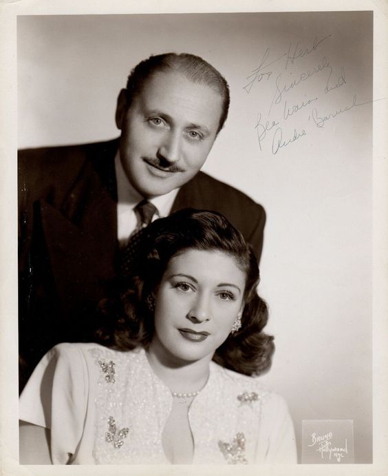 1940s vintage photo of BEA WAIN and ANDRE BARUCH. Bea is wearing a 1940s dress and a 1940s hairstyle. 