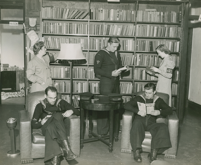 1940s Vintage Photo of the Halifax naval reading service in 1942. The image feattures sailors reading and volunteers helping to stock shelves. 