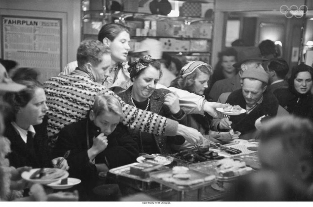 1940s Vintage Photo of the Olympic Games at St. Moritz, Switzerland 1948. The vintage photo features olympic athletes and others enjoying lunch.