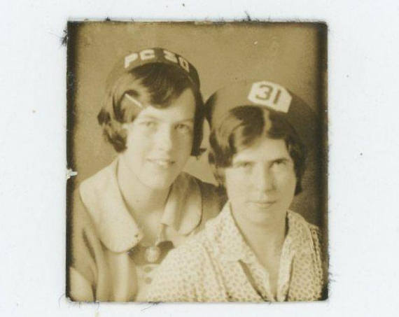 1920s vintage photobooth image of two women wearing novelty hats. 