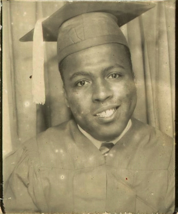 "Graduation Smile" vintage photo of a young Black Man in a graduation cap and gown posing in a photobooth.