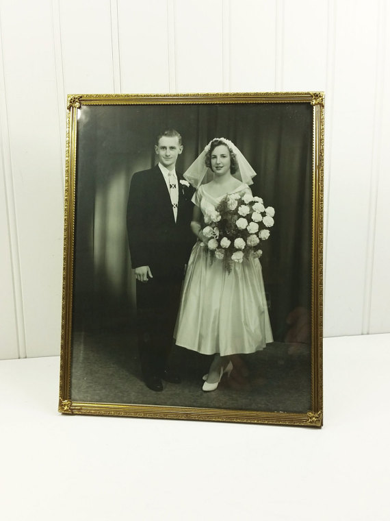 1950s Vintage Wedding Photo: 1950s bride and groom vintage photo. Bride is wearing a tea length wedding dress and short veil. 