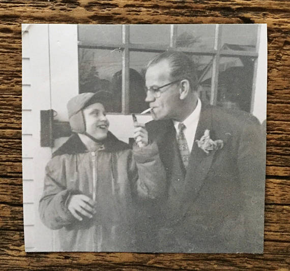 1950s vintage photo of son and father with father smoking