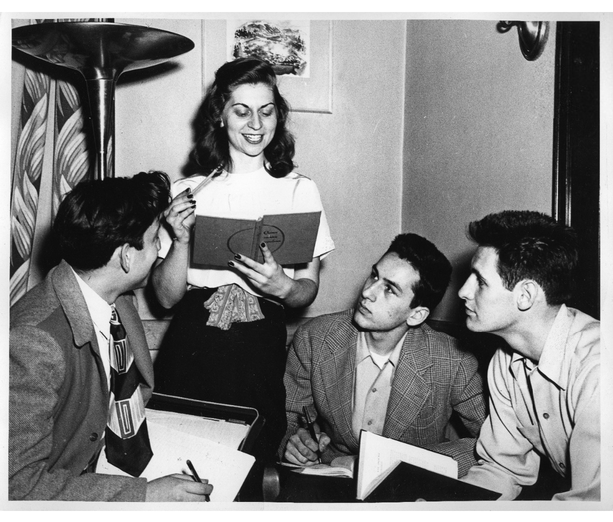 1940s 1950s Student Life Vintage Photos from University featuring a young woman teaching 3 men a topic on something from school. 