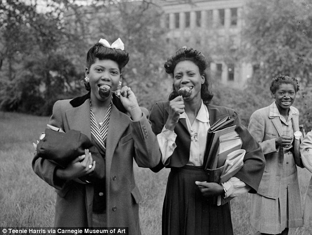 1940s vintage photo of young Black Women college students eating candy apples holding books and showcasing 1940's hairstyles