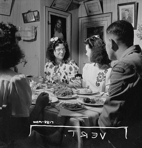 Women munitions workers of the Dominion Arsenals Ltd. plant dining with friends. 24 Aug. 1942 WW2 Homefront Canada vintage photo. The image also showcases women's 1940s hairstyles. 