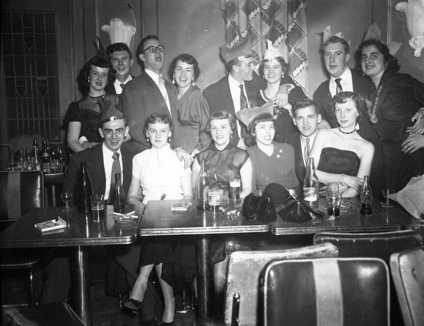 1950s Vintage Photo of Customers at the Standish Hall Hotel posing at their table, some wearing paper hats. Super 1950s Fashions and 1950s Hairstyles. 