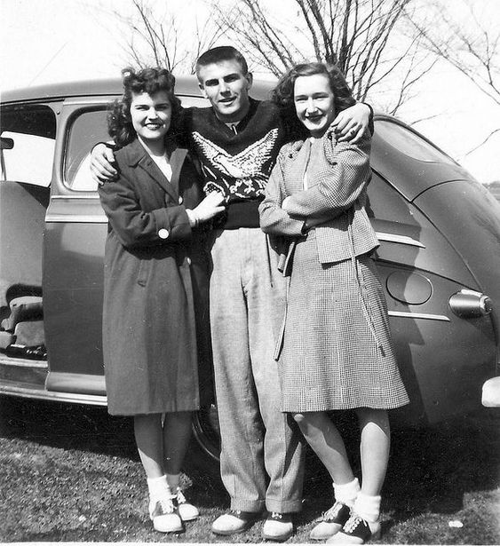 1940s vintage photo of 2 young women and a young man wearing saddle shoes in front of a car.