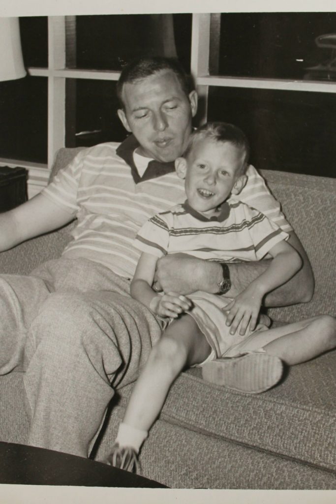 1950s photo of a father and son sitting on a couch vintage photo