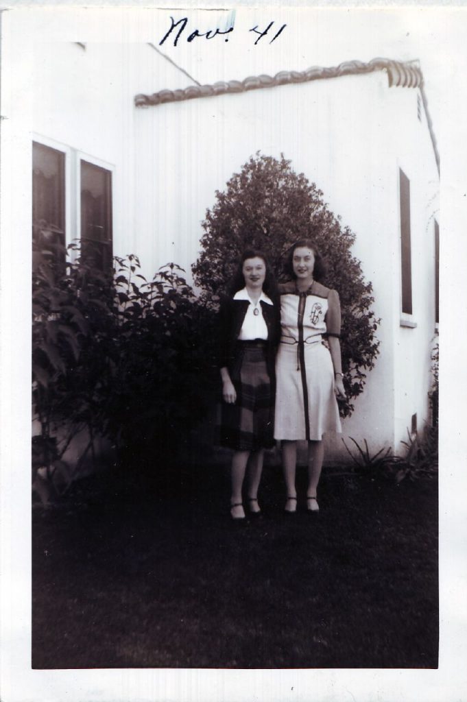 1940s vintage photo of 2 young women in 1940s fashions. 1940s dress and 1940s skirt, blouse and sweater. November 1941