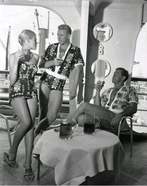 1950s Cruise Wear Fashions Swmsuits and Mens 1 piece swimwear. Matching Hawaiian print men's and women's swimsuits as seen in this 1950s photo. 