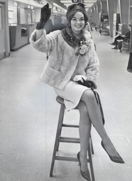 1960s vintage photo of Miss Dominion of Canada 1962 in 1960s fashion. Marlene Leeson of Huntsville; Miss Dominion of Canada 1962; waits at Malton Airport for a plane which took her to London for the Miss World Contest.