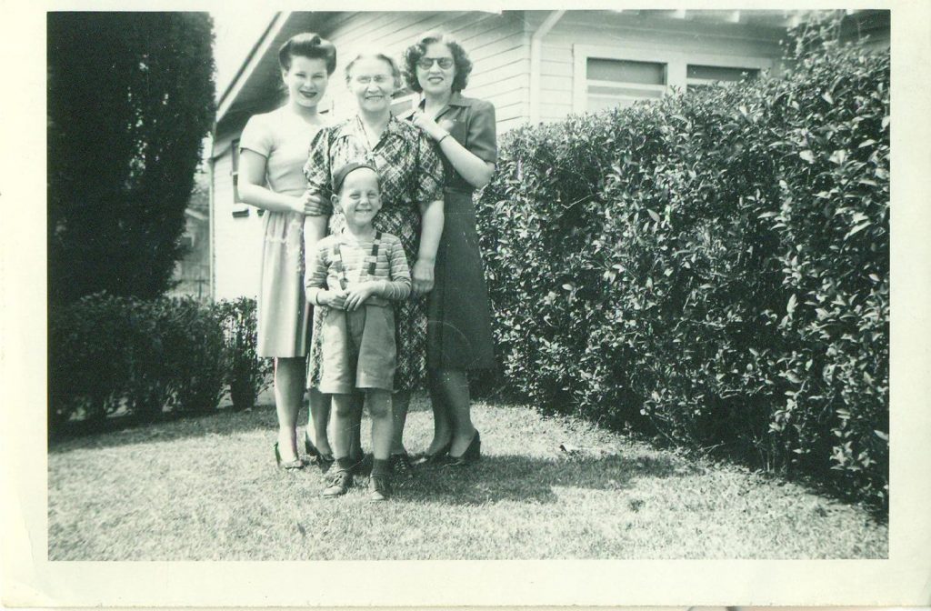 1940s vinage photo of a family in 1940s fashions posing together for a photo. 