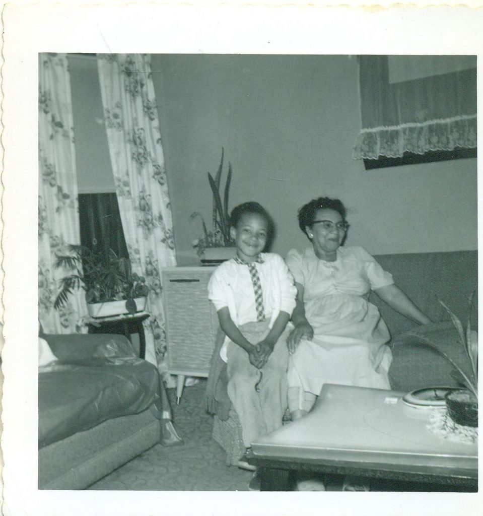 1950s Photo of an african American grandmother and grandchild posing together on the couch. 