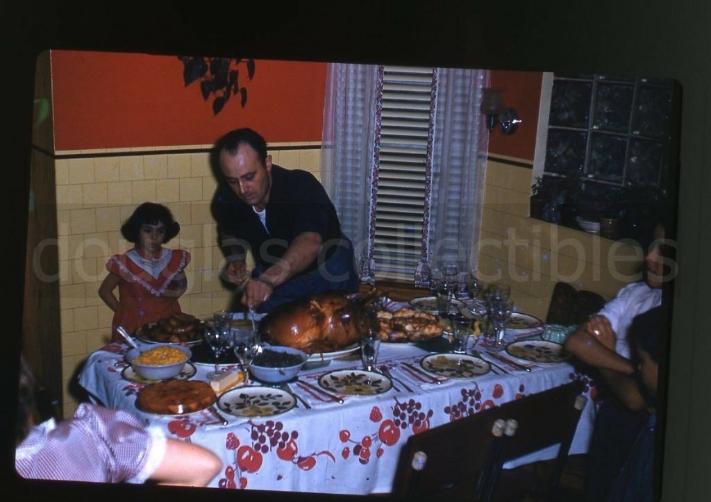 1950s thanksgiving dinner photo of a dad getting ready to carve the turkey