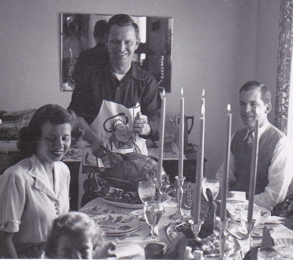 carving the turkey on thanksgiving day. 1950s photos of a family around the table