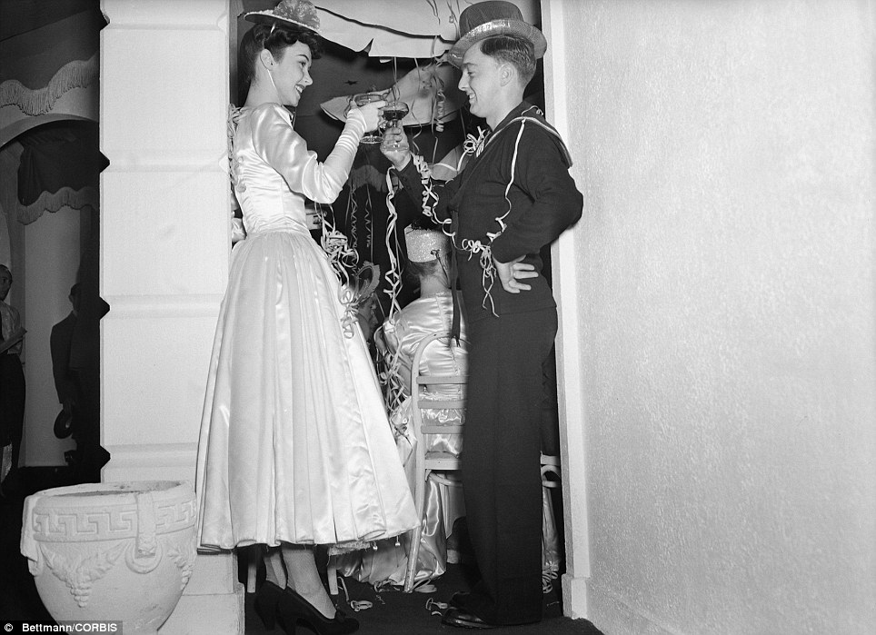 1940s vintage photo:Two young party goers toasted - 'To your bright eyes and lovely smile, honey,' and 'To your courage and safe return, sailor' as 1943 approached