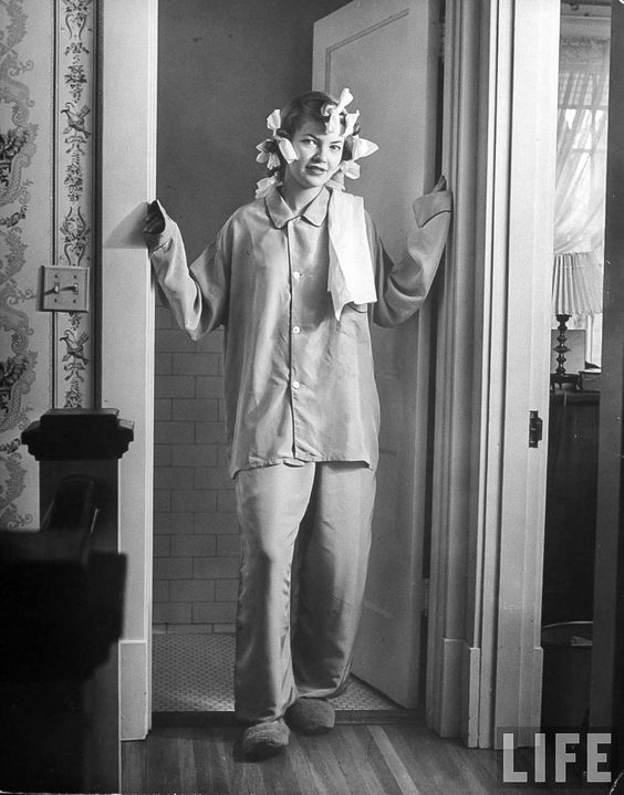 1950s vintage photo of a girl with rags in her hair for rag curls. 