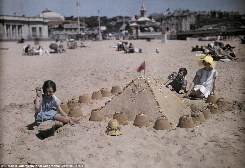 1930s vintage photo: A family builds a sandcastle at the seaside resort of Sandbourne, near Bournemouth in Dorset in 1932