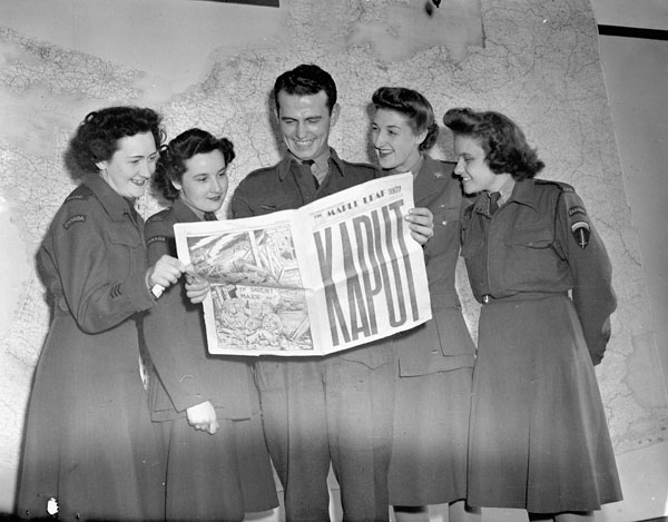 1940s vintage photo of a group at SHAEF Headquarters reading the special VE-Day edition of the Maple Leaf newspaper, Paris, France, May 11, 1945