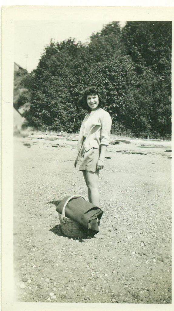 1940s vintage photo of a Summer Picnic featuring a Woman with Basket & Blanket by the River 