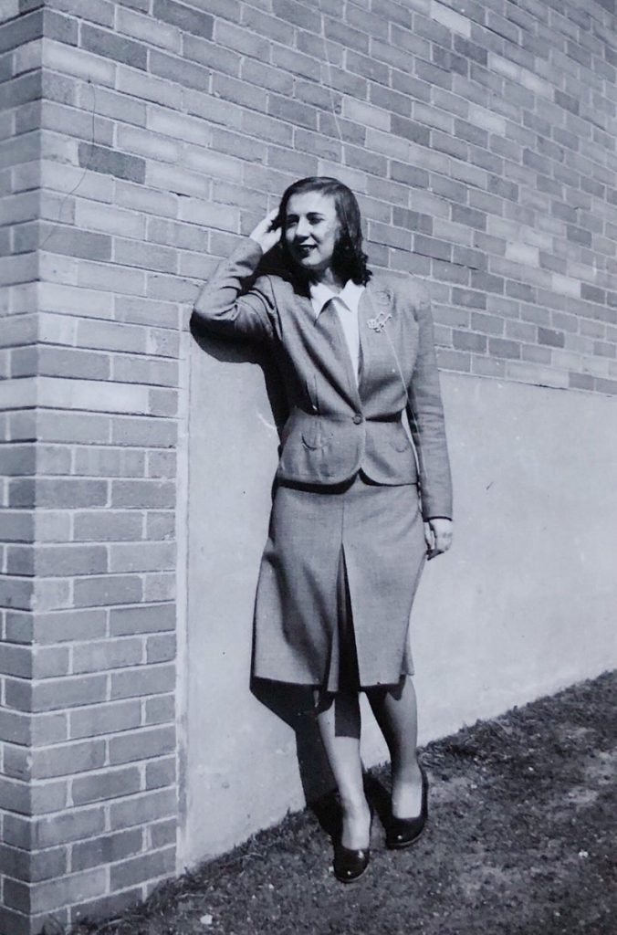 1940s vintage photo of a woman wearing a 2 piece skirt suit with brooch. Great Street Style!