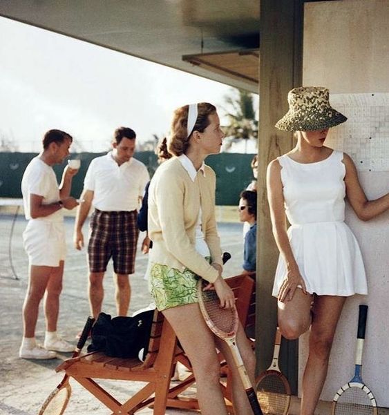 Tennis in the Bahamas, 1957. Photo: Slim Aarons. 1950s fashion photo of 2 women in Tennis Outfits and 2 Men in bermuda shorts.  Vintage Tennis Outfit Inspiration. 