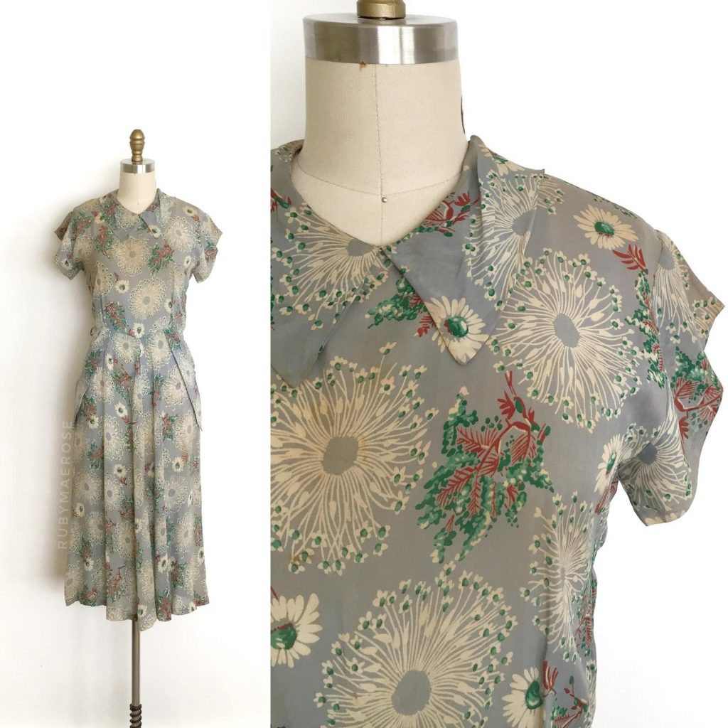 1940s Fashion: Gorgeous 1940’s printed rayon dress. This dress features a unique all over print that has a floral motif and trees in a muted soft blue, green and brown.