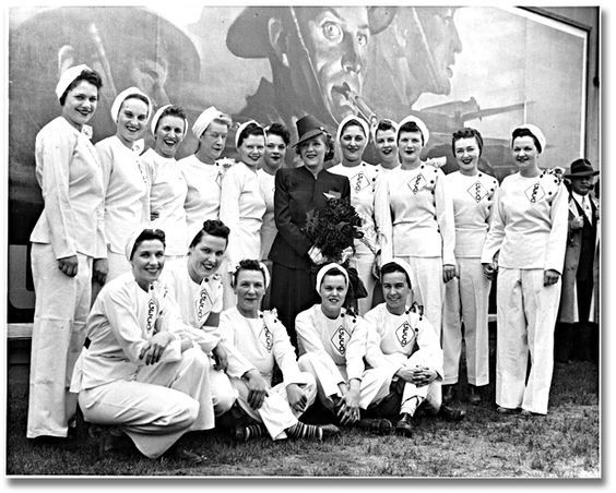 Actress Mary Pickford posing with a group of employees during her visit to the General Engineering Company (Canada) munitions factory, June 5, 1943.