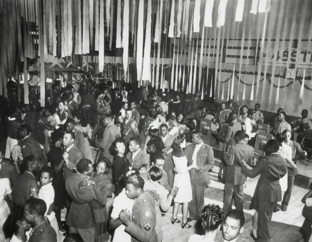 This Christmas dance in the 1940s was sponsored by the 1323rd Engineers in Texas. 1940s Vintage Photo of Black Men & Women at a Dance in 1940s Fashions. 