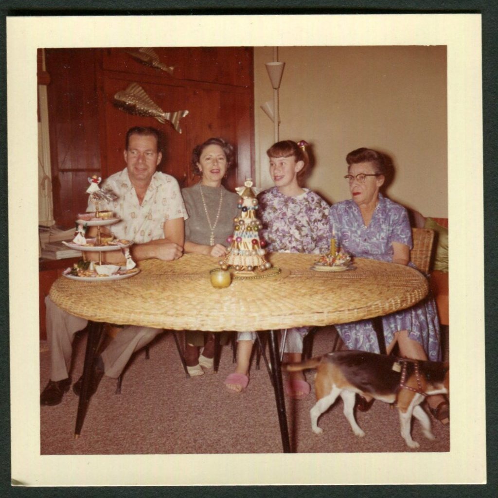 Vintage Photo Mid Century Family at Christmas 1960's sitting at a rattan table with christmas treats and a dog