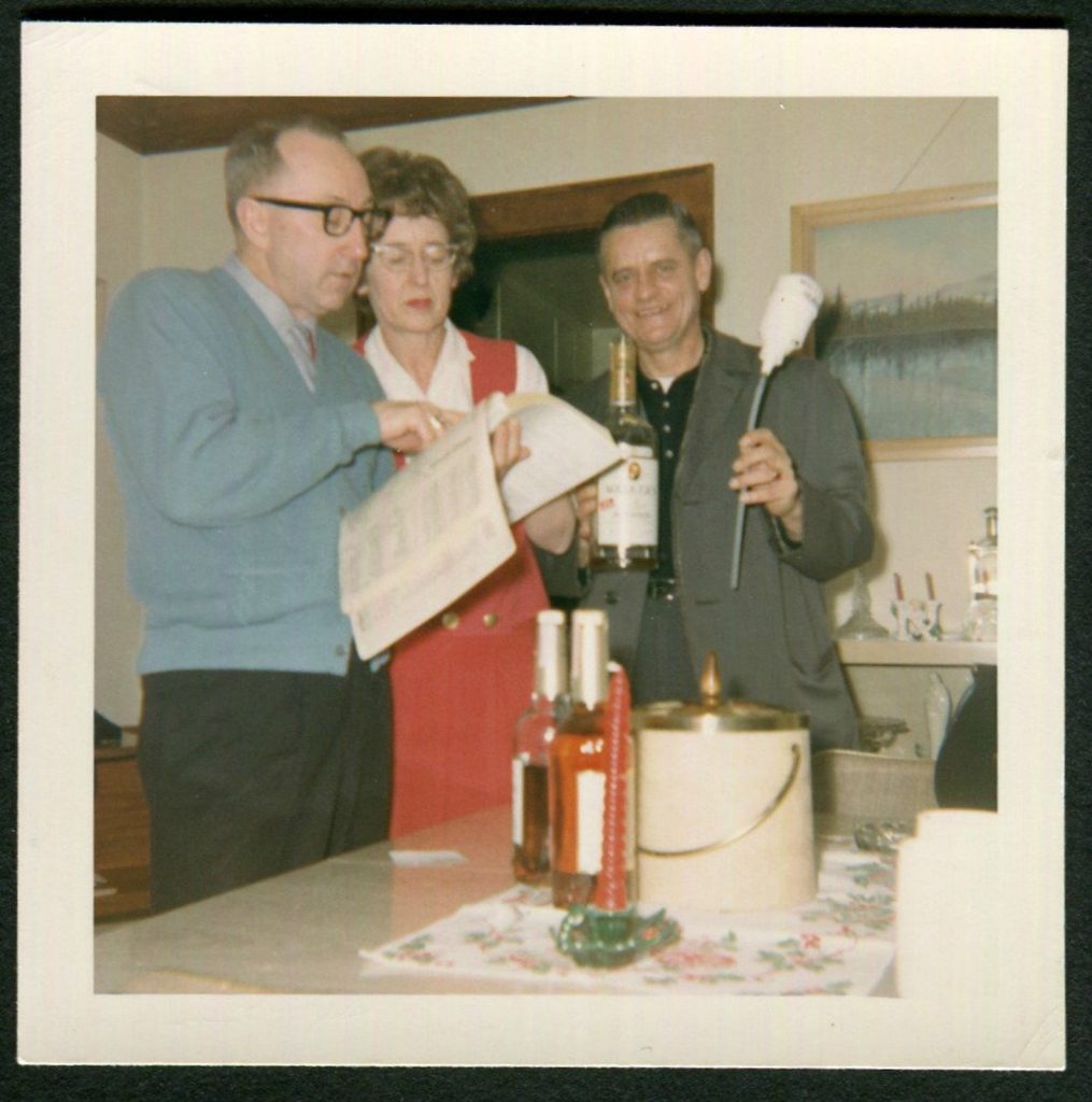 1960s vintage photo: 1960s photo of a group of party goers trying to figure out how to make their next drinks.  