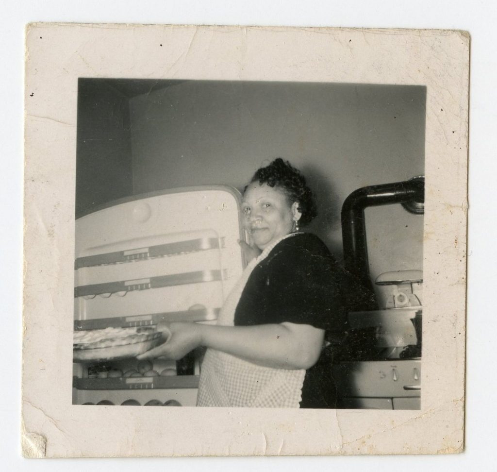 1940s photo of a Black woman baking a pie in her kitchen